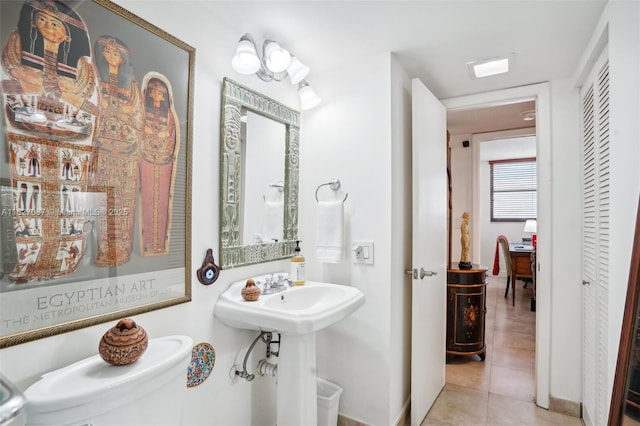 bathroom featuring a sink, tile patterned floors, and toilet