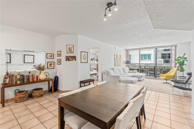 tiled dining room with expansive windows and a textured ceiling