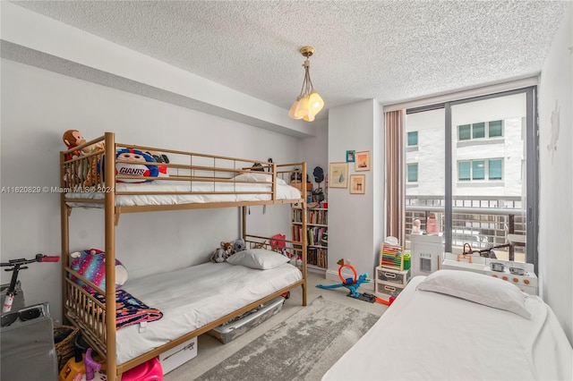 carpeted bedroom with expansive windows and a textured ceiling