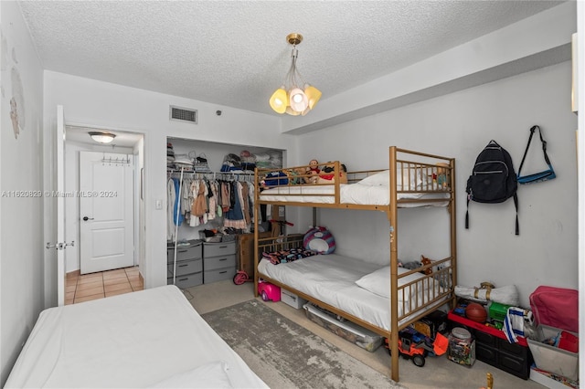 bedroom featuring a chandelier, a closet, and a textured ceiling