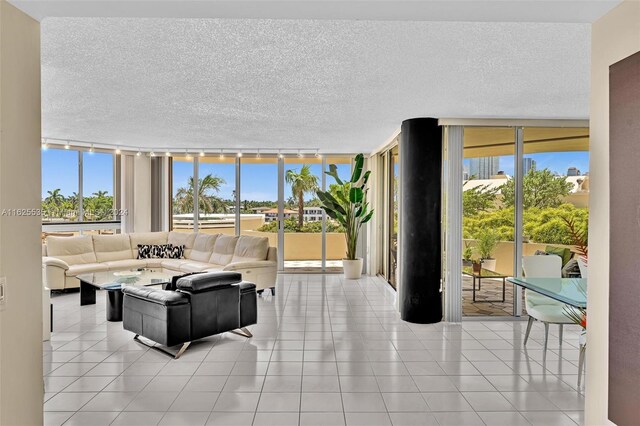 tiled living room featuring expansive windows and a textured ceiling