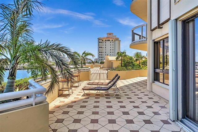 view of patio featuring a balcony and a water view