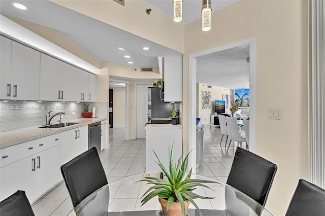 tiled dining room with sink and a textured ceiling