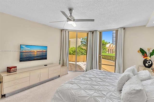 bedroom featuring light carpet, a textured ceiling, access to exterior, and ceiling fan