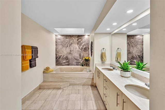 bathroom with dual vanity, tile patterned floors, and a bath