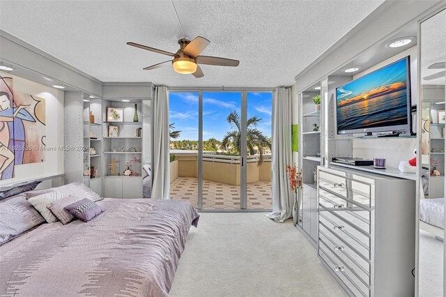 bedroom with access to outside, a textured ceiling, light colored carpet, and ceiling fan