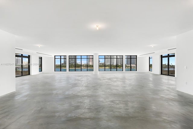 unfurnished living room with concrete flooring and a healthy amount of sunlight