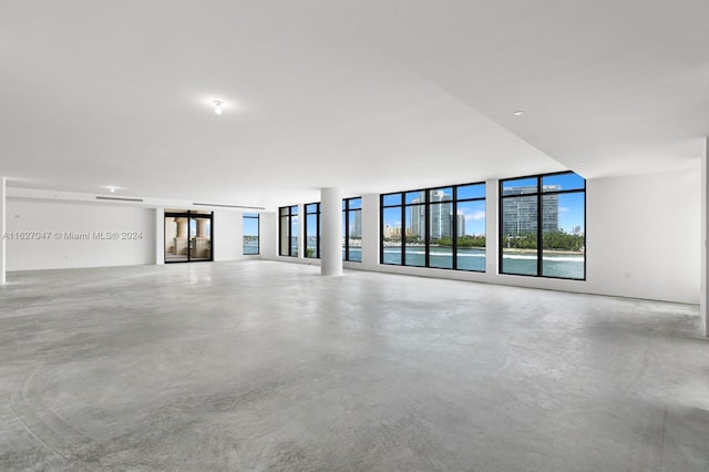 unfurnished living room featuring a wall of windows and concrete floors