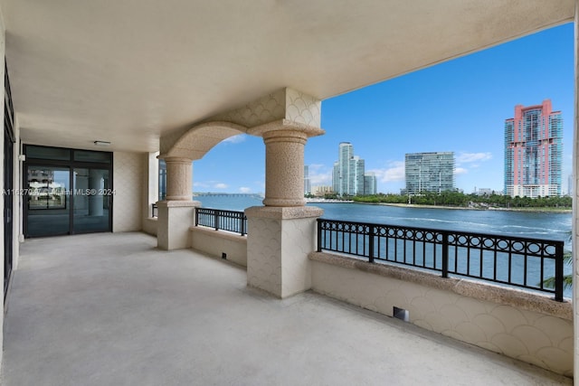 view of patio featuring a water view and a balcony