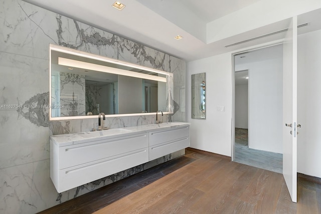 bathroom with tile walls, vanity, and wood-type flooring