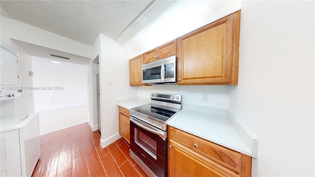 kitchen with a textured ceiling, hardwood / wood-style floors, and electric stove