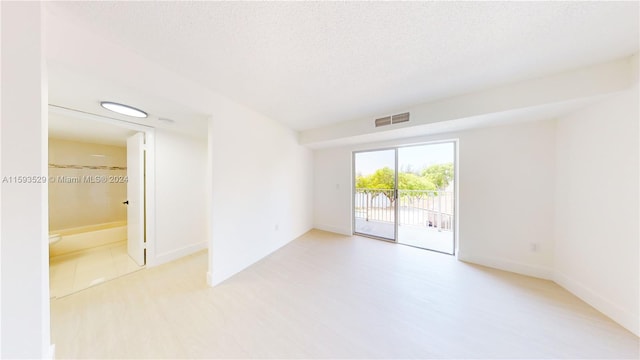 unfurnished room with a textured ceiling