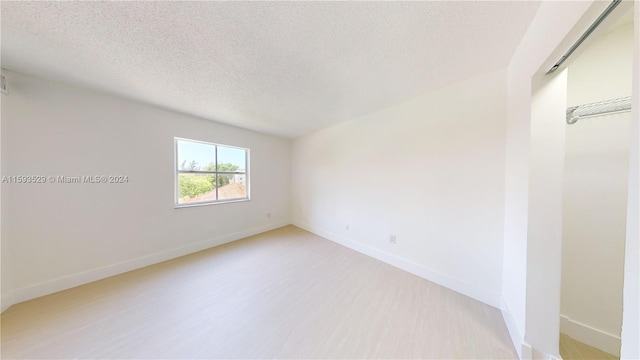 unfurnished room featuring a textured ceiling