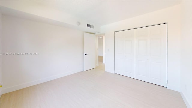 unfurnished bedroom featuring light hardwood / wood-style floors and a closet