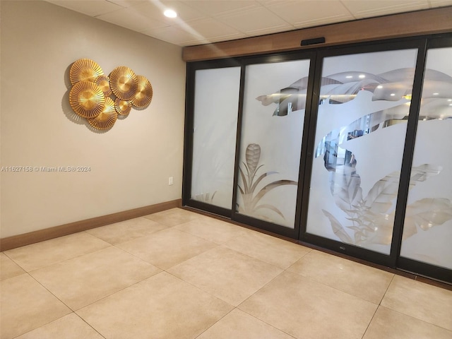 tiled empty room with a drop ceiling