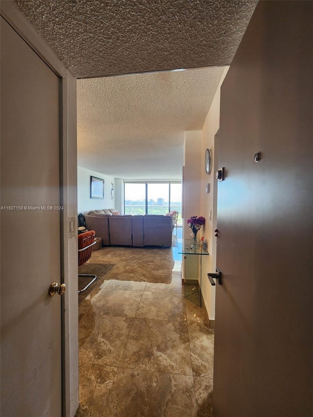 corridor featuring a textured ceiling and tile patterned flooring