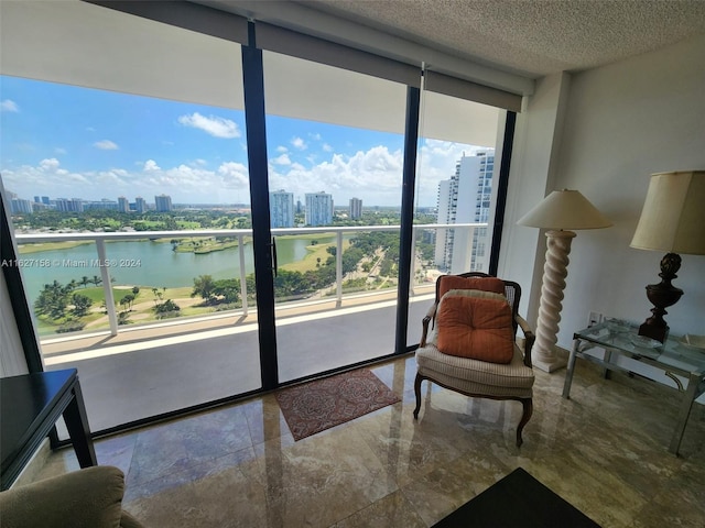 sitting room featuring tile patterned floors, a textured ceiling, and a water view