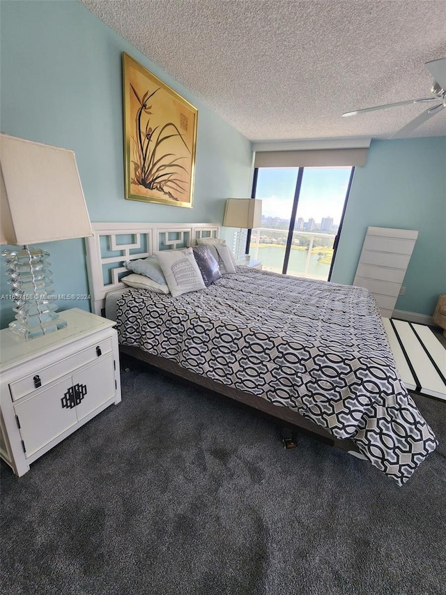 carpeted bedroom with ceiling fan and a textured ceiling