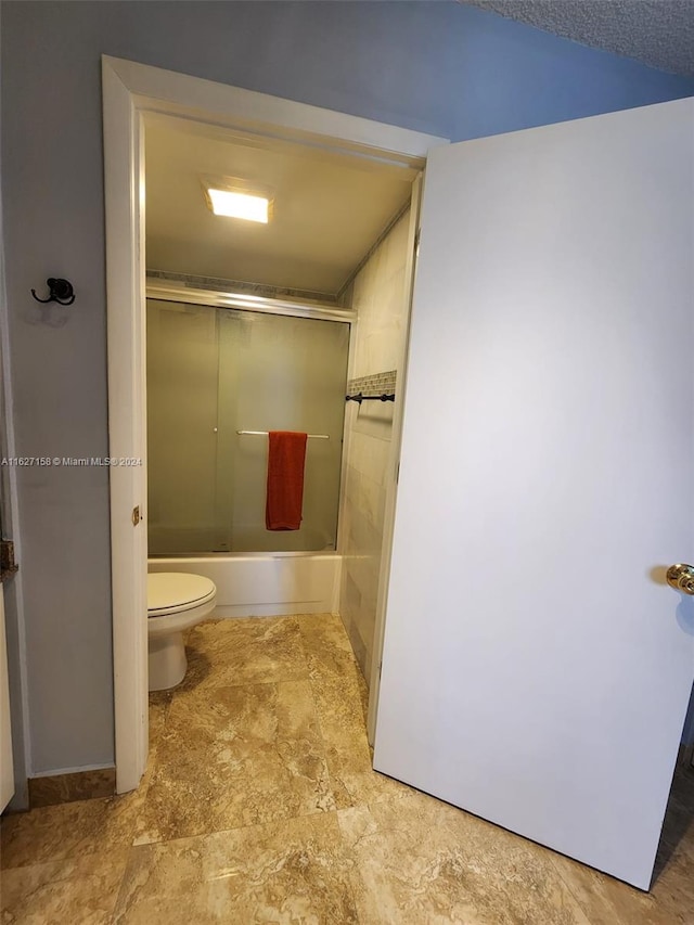 bathroom with tile patterned flooring, toilet, and enclosed tub / shower combo