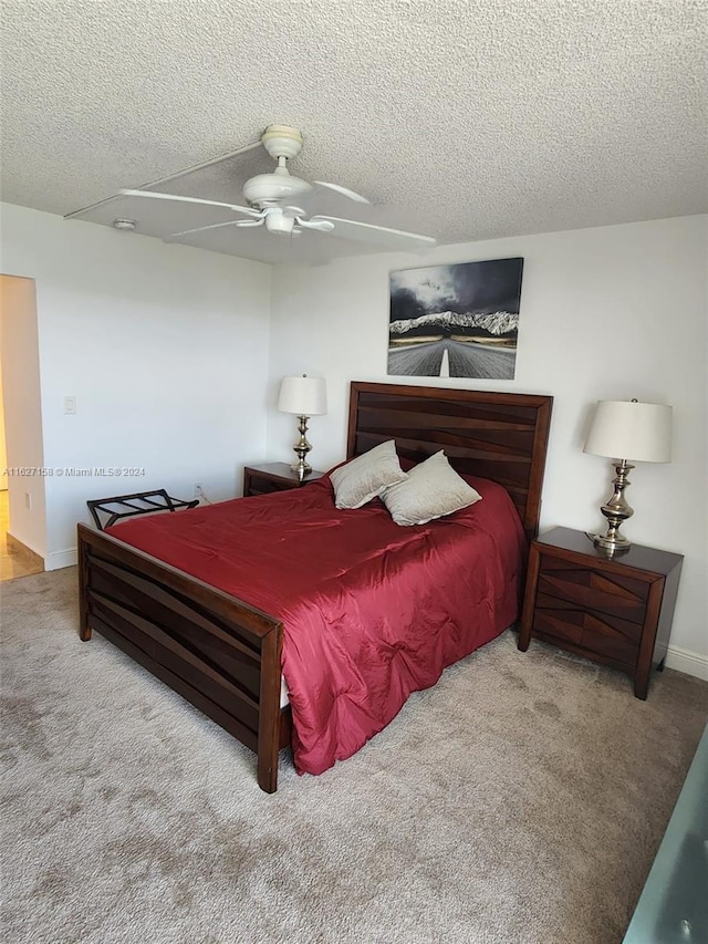 bedroom with a textured ceiling, carpet, and ceiling fan