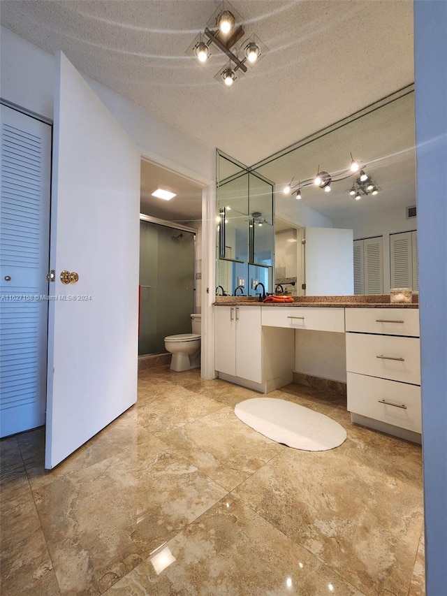 bathroom with vanity, a textured ceiling, toilet, and tile patterned flooring