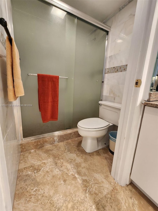 bathroom featuring tile patterned flooring, a shower with shower door, and toilet