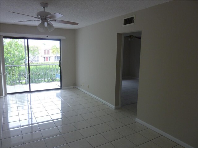 tiled empty room featuring a textured ceiling and ceiling fan