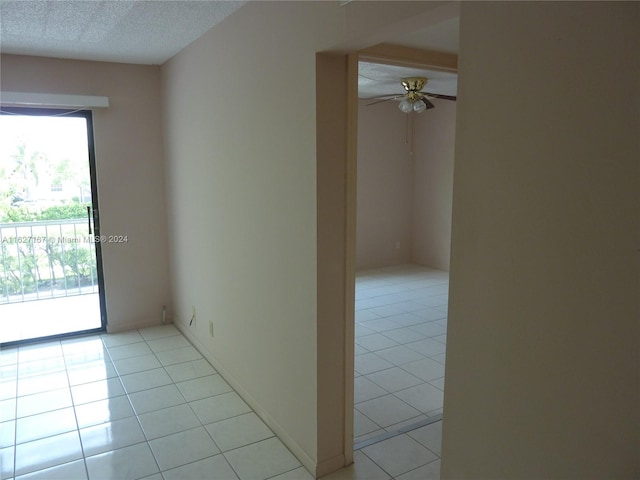 tiled spare room with a textured ceiling and ceiling fan