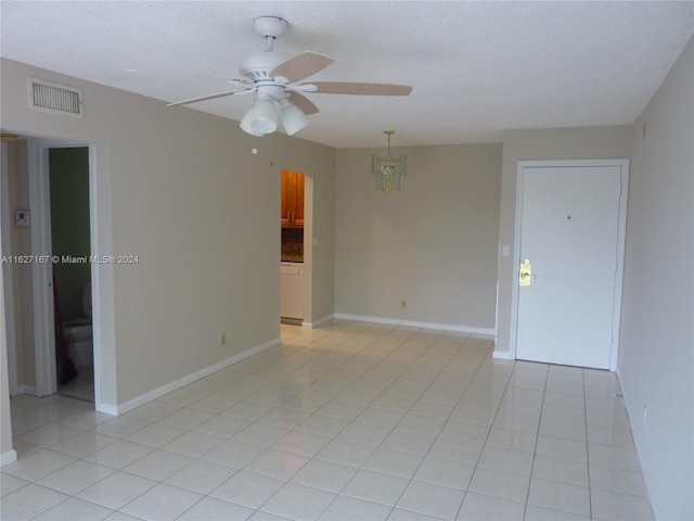 tiled spare room featuring ceiling fan