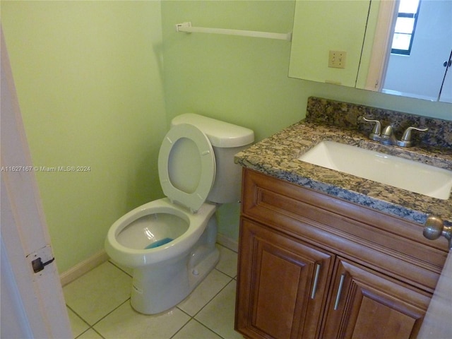 bathroom with toilet, tile patterned flooring, and vanity