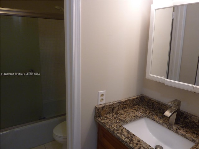 full bathroom with shower / bath combination with glass door, vanity, tile patterned floors, and toilet