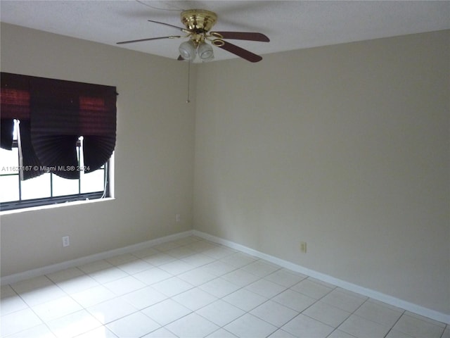 spare room with light tile patterned flooring and ceiling fan