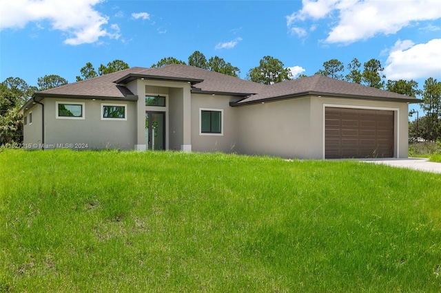 prairie-style house with a garage and a front lawn