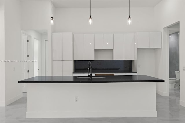 kitchen featuring sink, a high ceiling, and a kitchen island