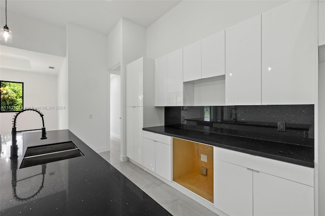 kitchen with light tile patterned floors, white cabinetry, sink, and pendant lighting