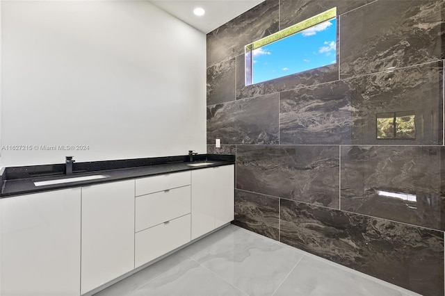 bathroom with sink, tile patterned floors, and tile walls