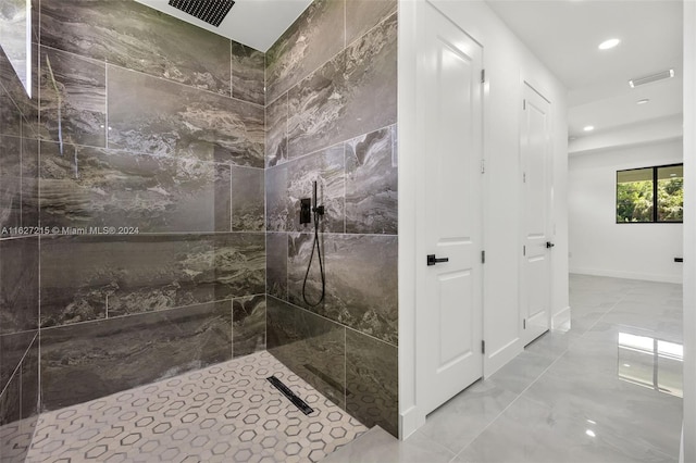 bathroom with tile patterned floors and a tile shower