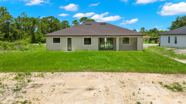 rear view of property featuring a yard