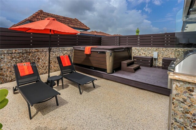 645 NE 9th Ave, Fort Lauderdale, FL 33304 - fenced backyard featuring a hot tub, a wooden deck, and a patio