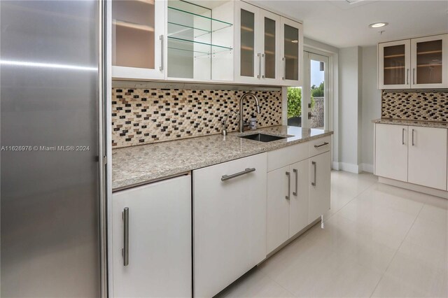 645 NE 9th Ave, Fort Lauderdale, FL 33304 - kitchen featuring a sink, backsplash, white cabinets, light stone countertops, and recessed lighting