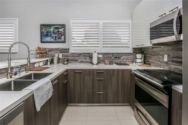 645 NE 9th Ave, Fort Lauderdale, FL 33304 - kitchen featuring stainless steel appliances, a sink, light countertops, and decorative backsplash