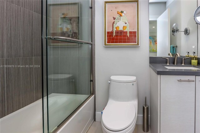 645 NE 9th Ave, Fort Lauderdale, FL 33304 - bathroom featuring toilet, vanity, and shower / bath combination with glass door
