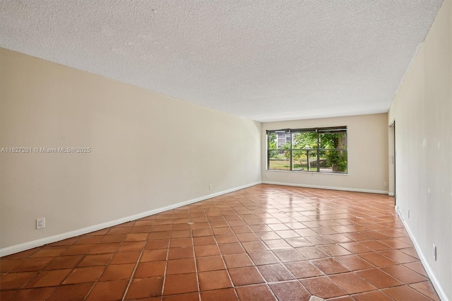 empty room with tile patterned floors and a textured ceiling