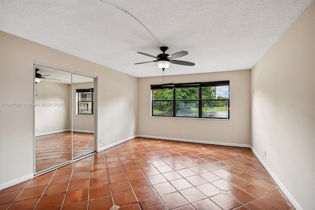 unfurnished bedroom with a textured ceiling, tile patterned floors, ceiling fan, and a closet