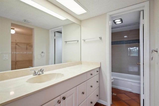 full bathroom with tile patterned flooring, vanity, tiled shower / bath, and toilet