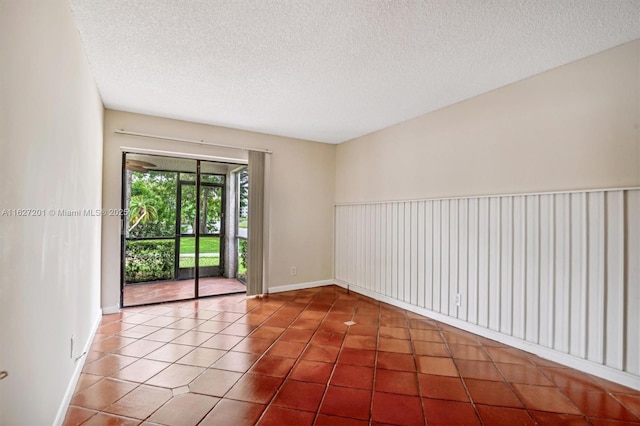 tiled empty room with a textured ceiling