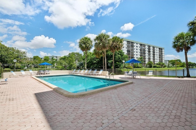 view of pool with a patio and a water view