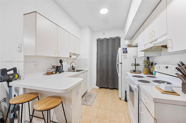 kitchen featuring light tile patterned floors, sink, white electric range, white cabinets, and a breakfast bar area