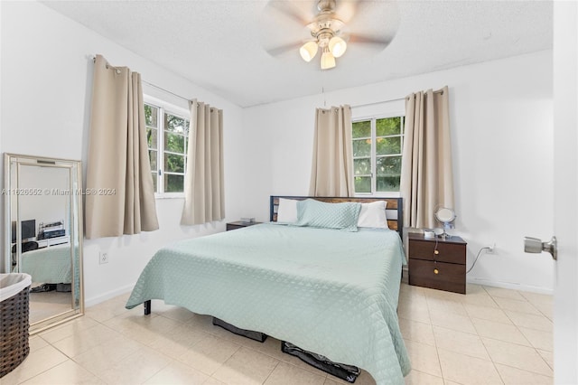 tiled bedroom featuring multiple windows, a textured ceiling, and ceiling fan