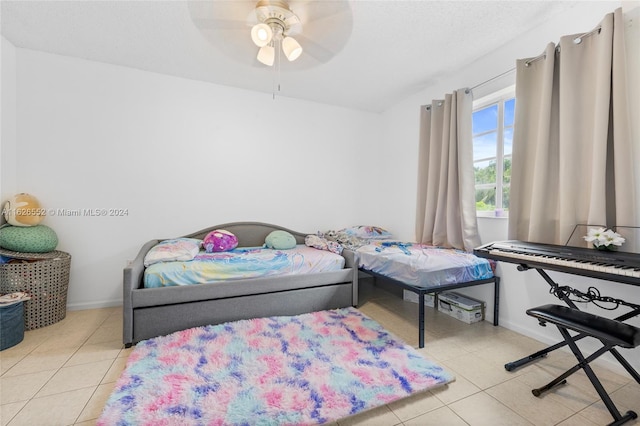 bedroom featuring a textured ceiling, ceiling fan, and light tile patterned floors